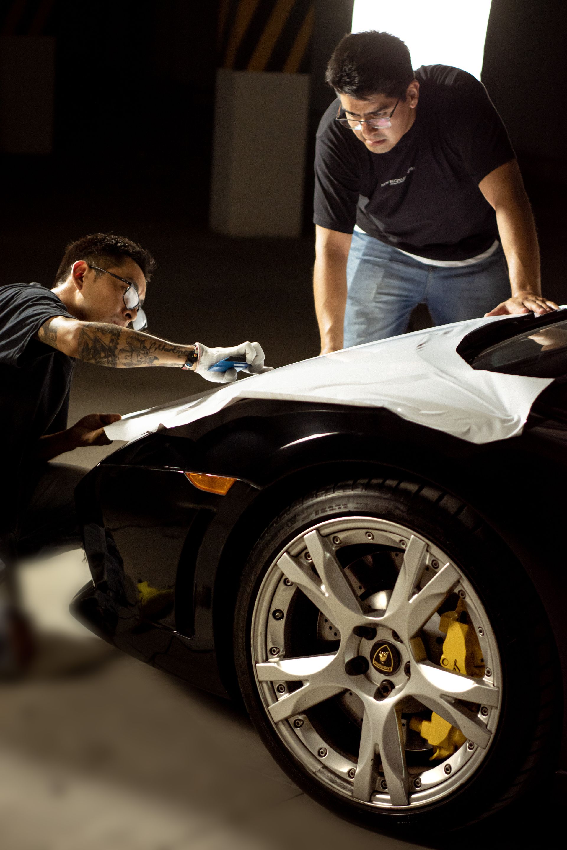 Paint protection film being applied to a sports car