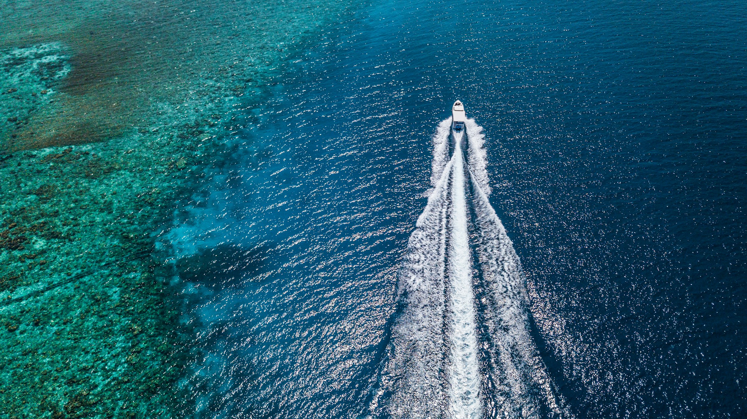 Boat cutting through open blue water